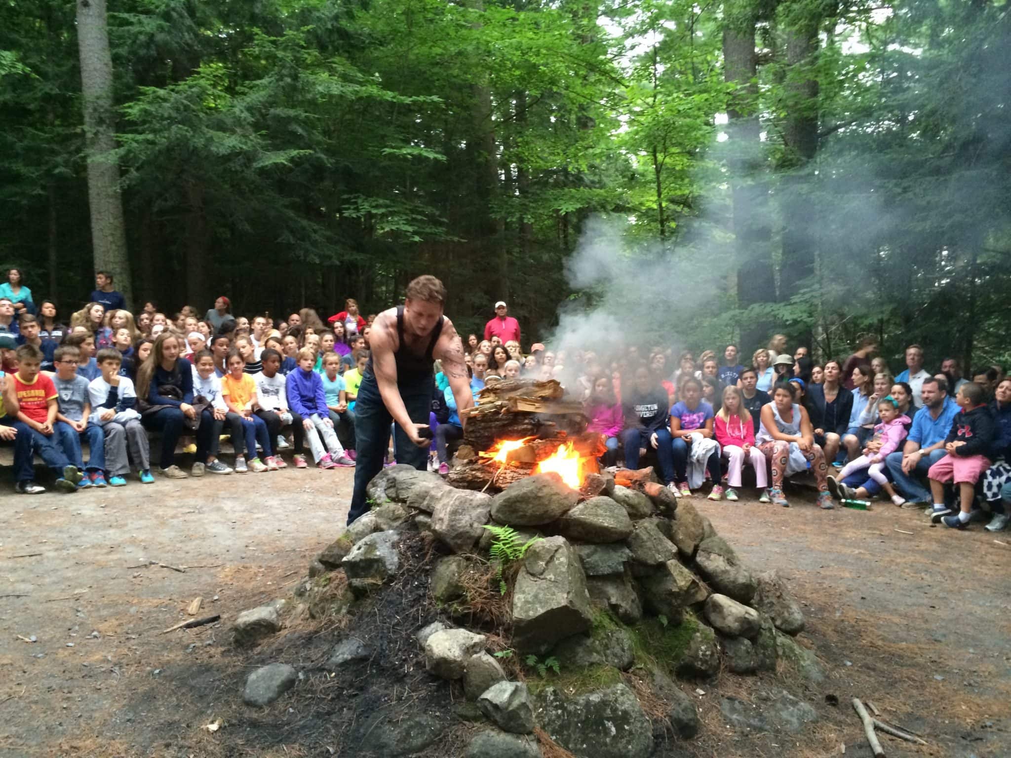 visitors gathered around campfire during day