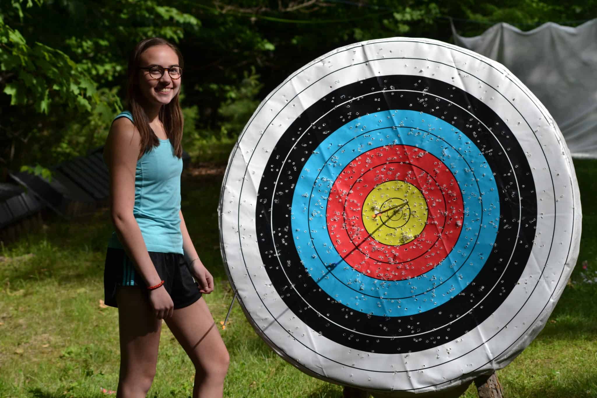 girl standing next to archery target