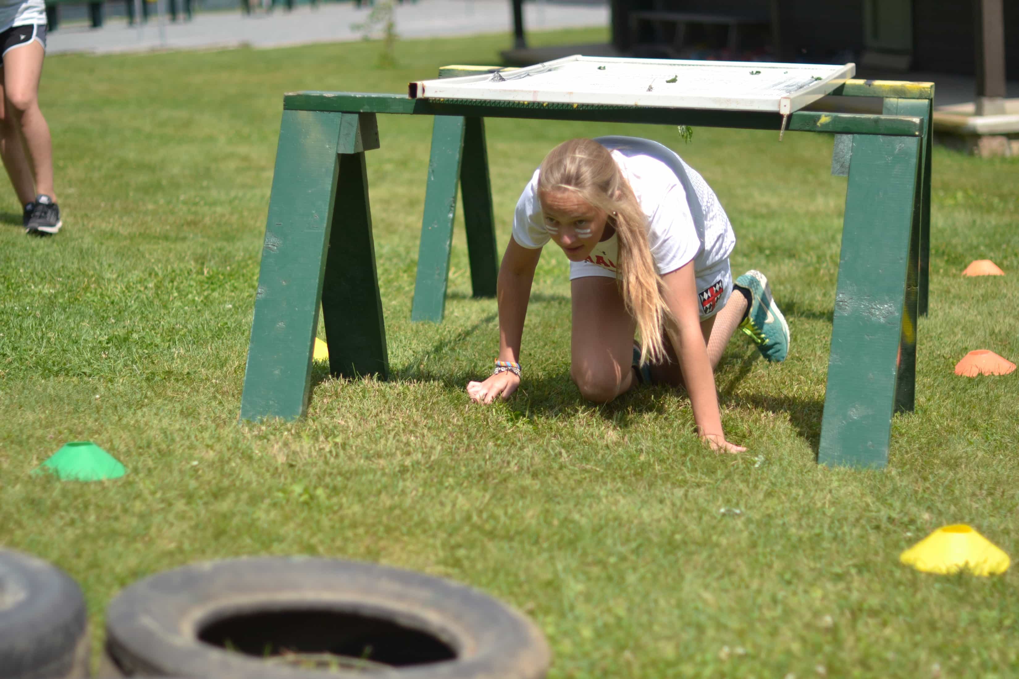 girl crawling under obstacle during relay