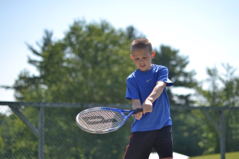 boy swinging tennis racket