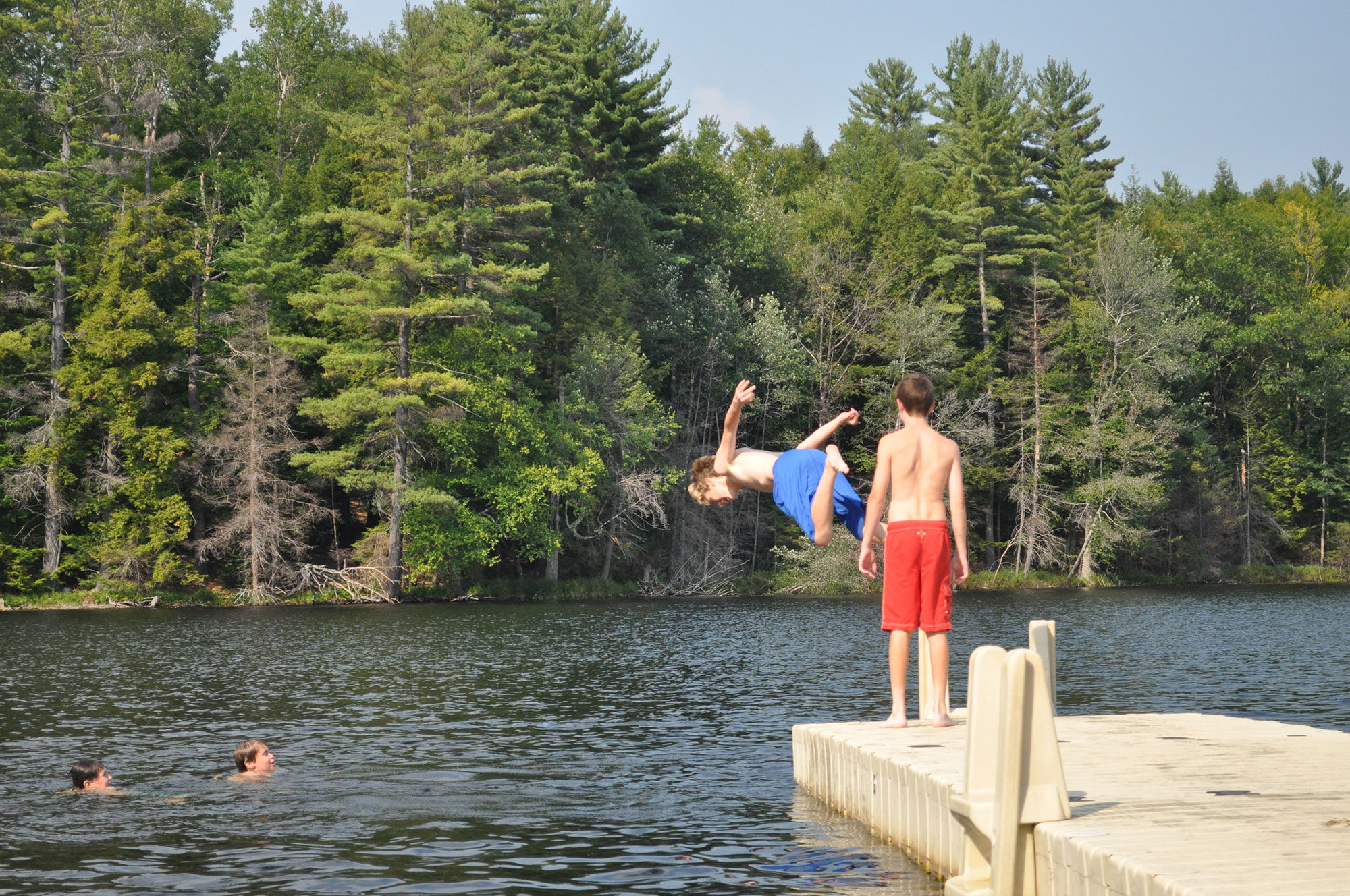 kids jumping off dock into water